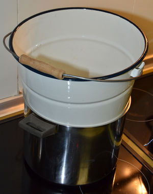 Plaats een bij voorkeur metalen emmer in de pot met bijna kokend water.