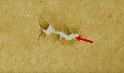 Left tear bij paper tuning. De nok en veren van de pijl slaan links in t.o.v. de plaats (rode pijl) waar de punt ingeslagen is.